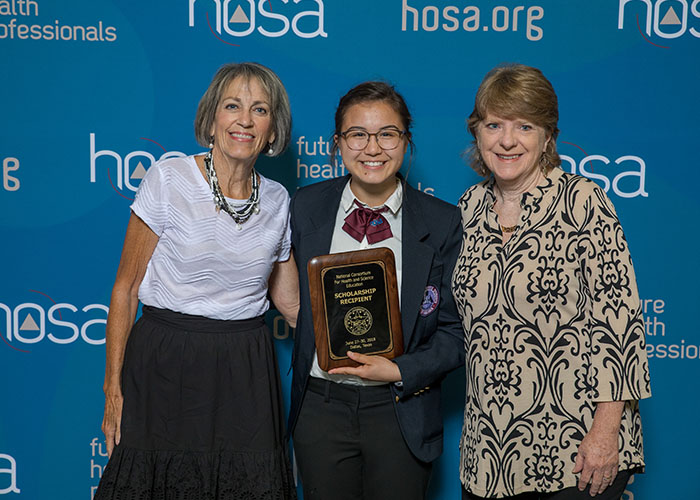 Adults posing with student who won an award